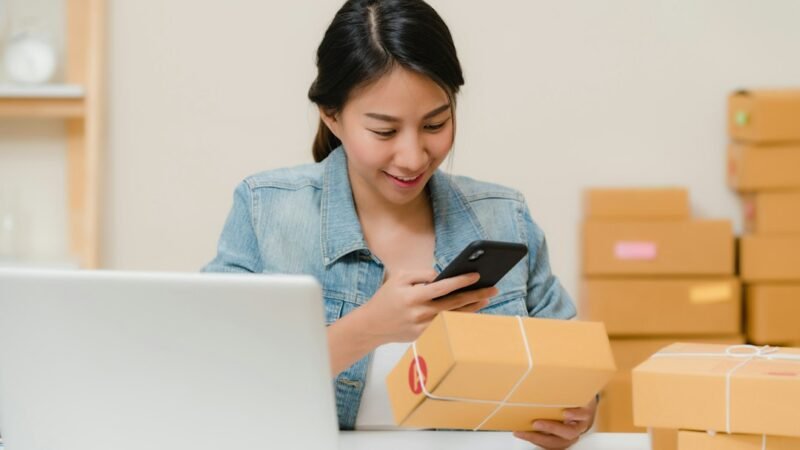 Small business owner packing ecommerce orders at a home workspace
