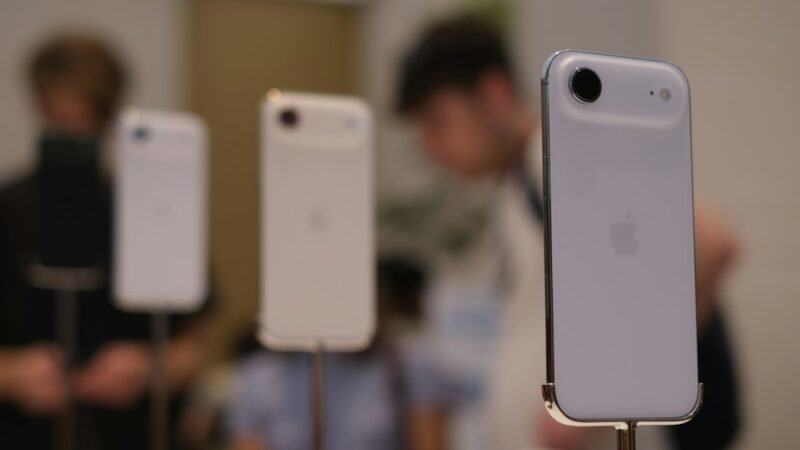 Several white smartphones displayed on stands in a retail store