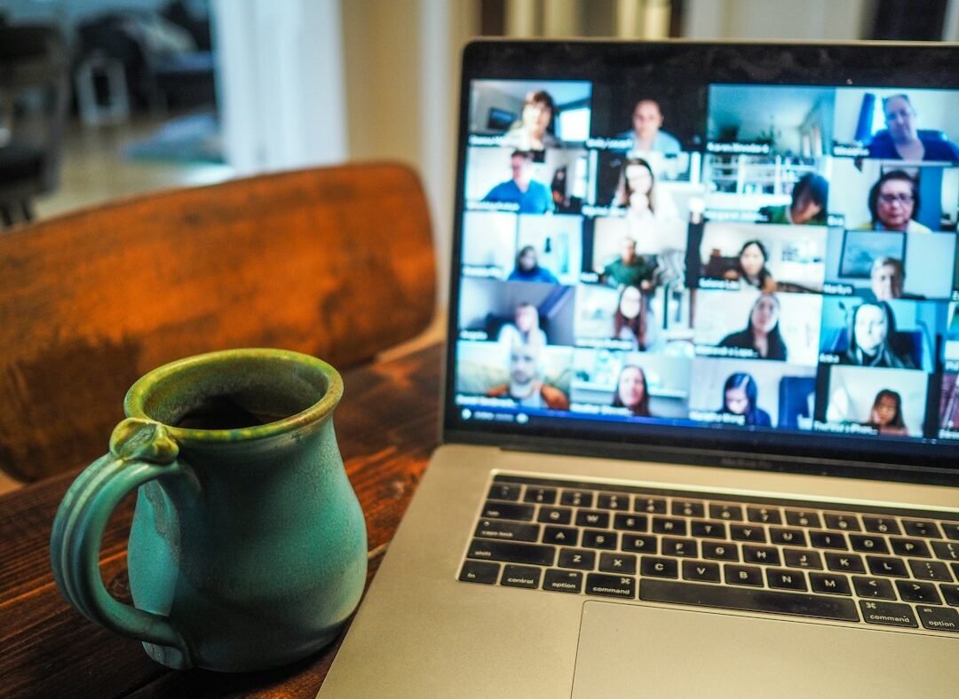 Laptop screen showing a video call with coffee cup nearby