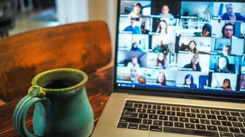 Laptop screen showing a video call with coffee cup nearby