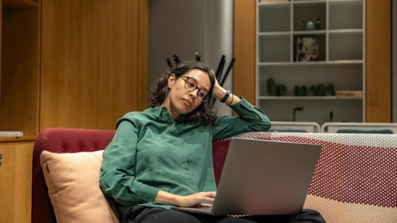 Woman working on a laptop in a relaxed office as part of a virtual assistant side hustle
