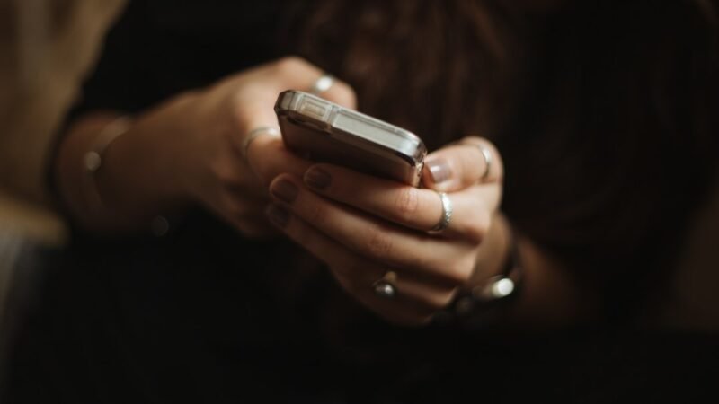 Person reading a short text reply on a smartphone, illustrating what MK means in text