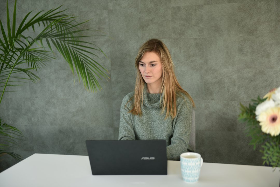 Woman working on a laptop in a home office on a side hustle