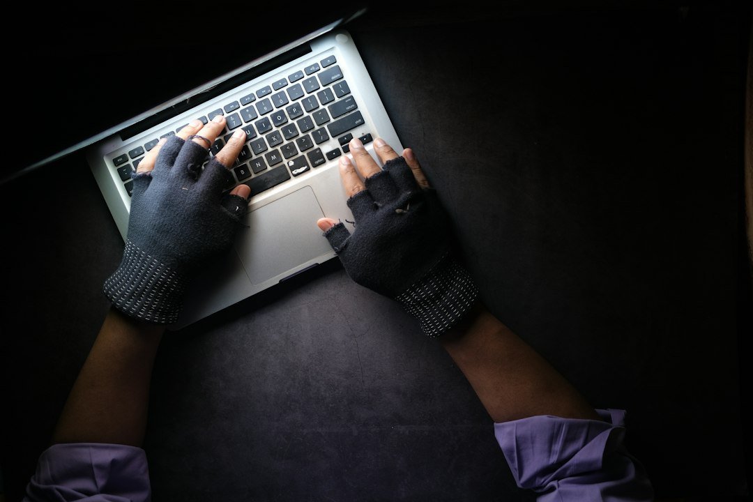 Hand typing on a laptop keyboard, representing a stolen-credential security incident