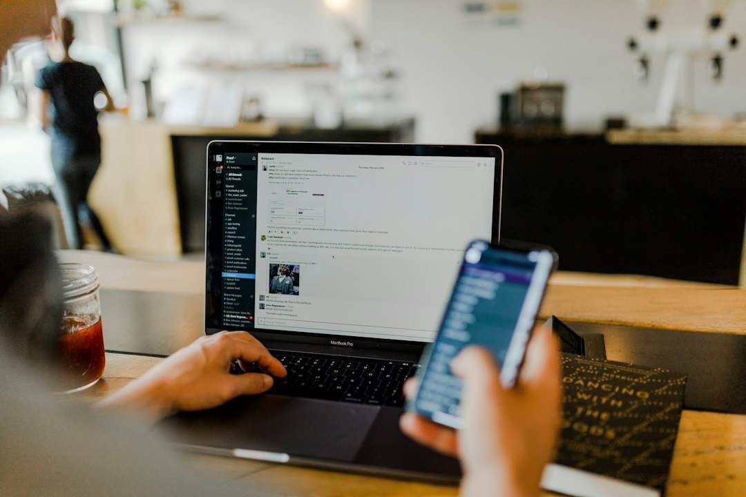 Team members messaging each other on phones and laptops in a modern workplace