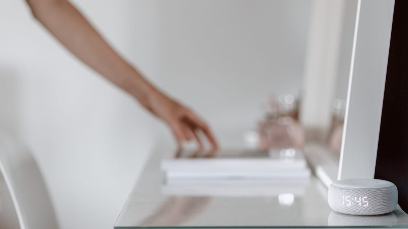 Smart speaker with a digital clock display on a minimalist desk