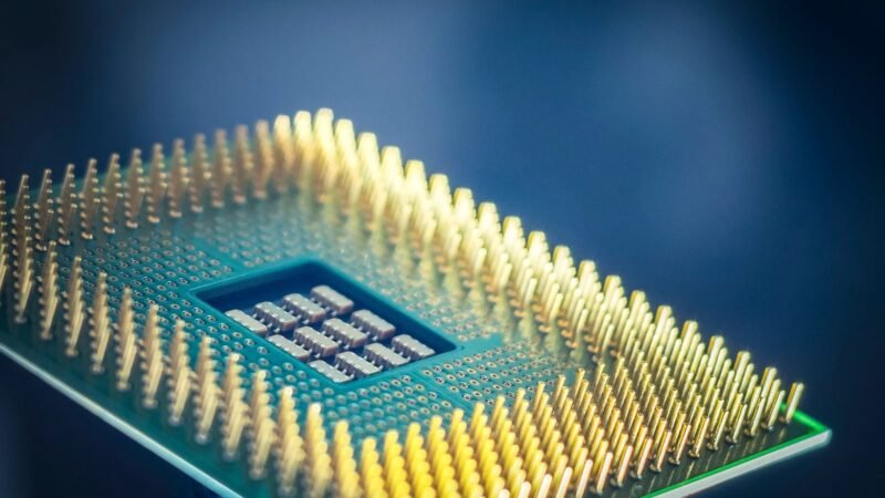 Close-up of a computer processor chip with gold pins on a dark blue background