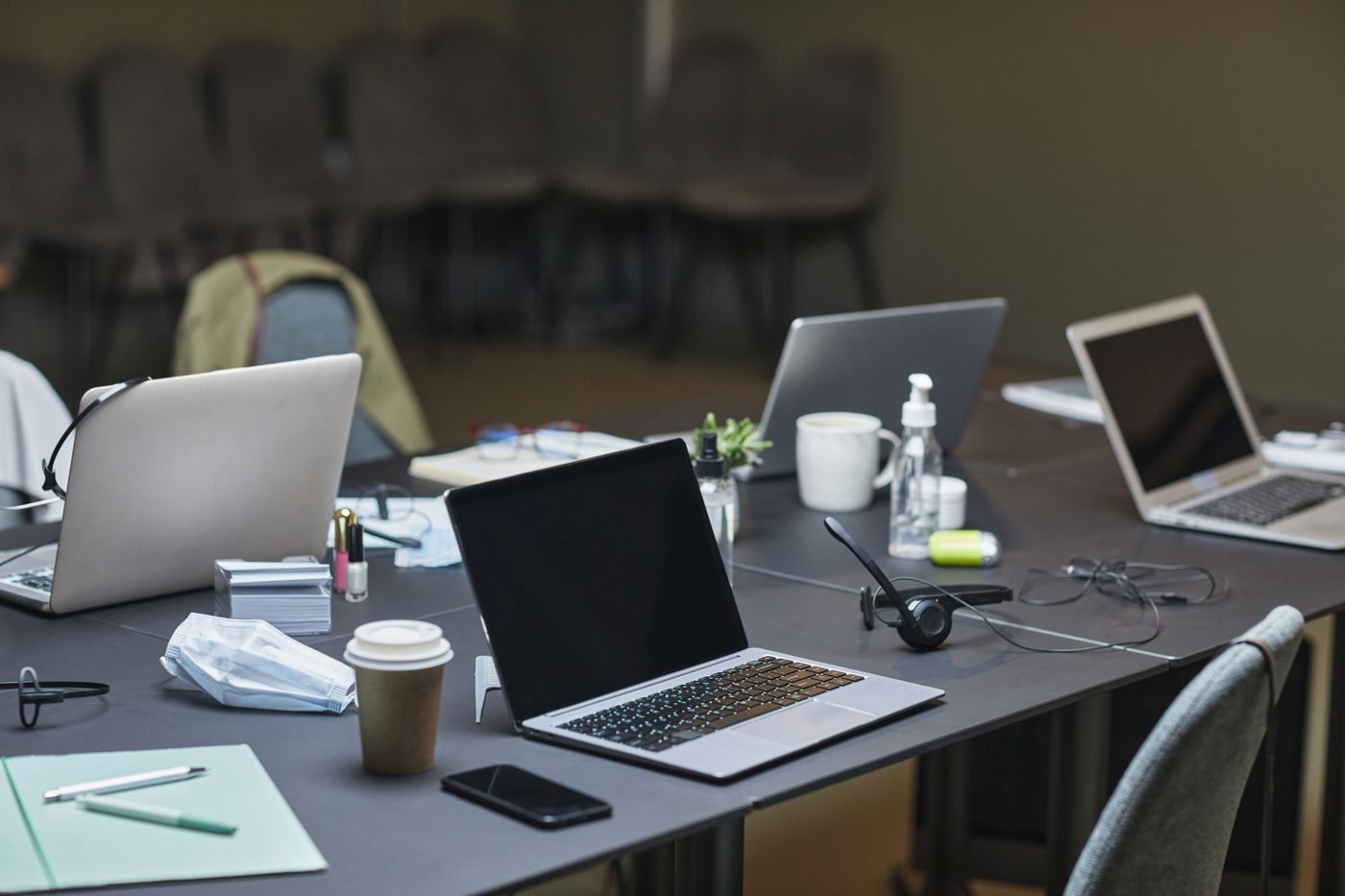 Office desk with several laptops and documents during a workday