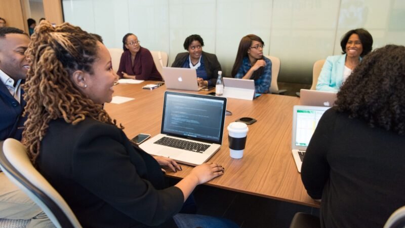 Team of professionals working on laptops around a conference table