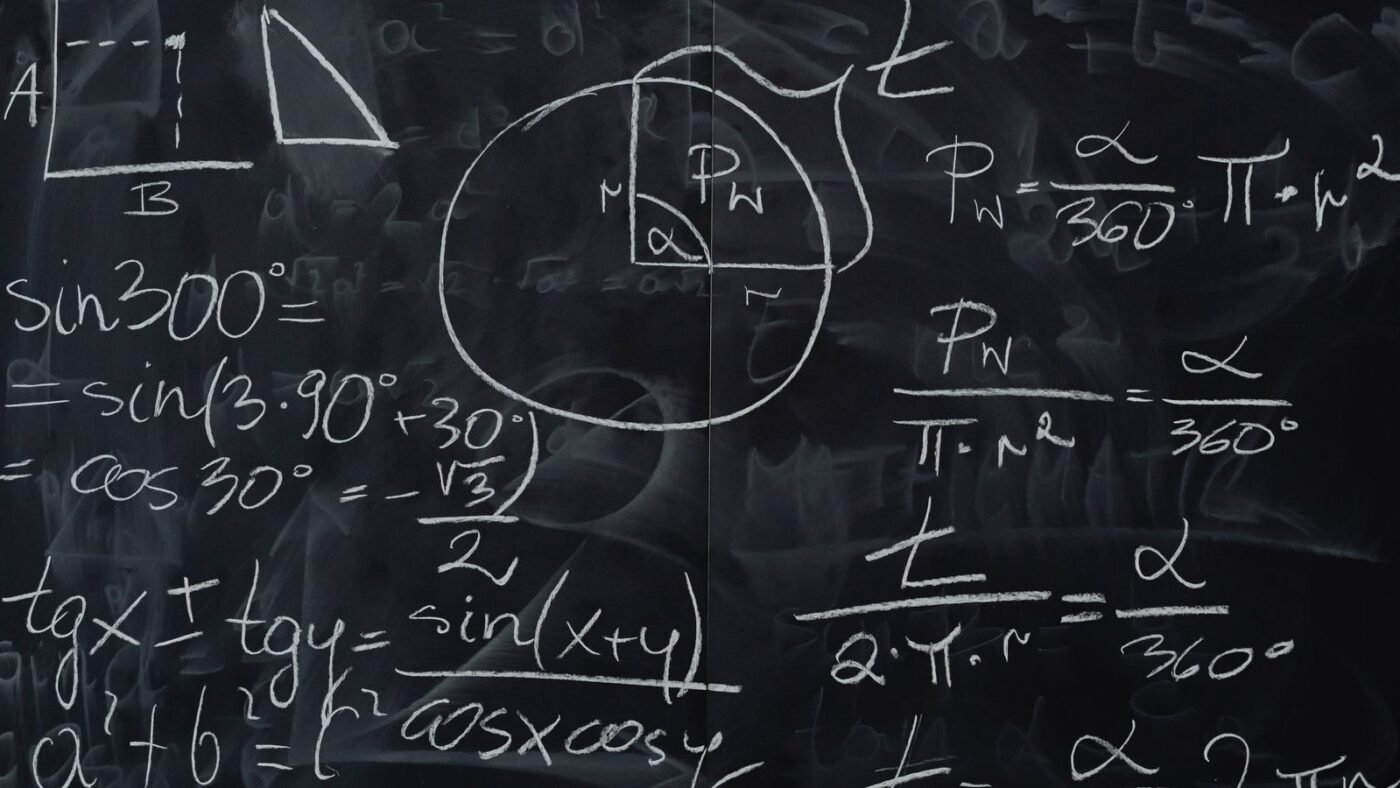 Mathematical equations and geometric diagrams drawn on a chalkboard