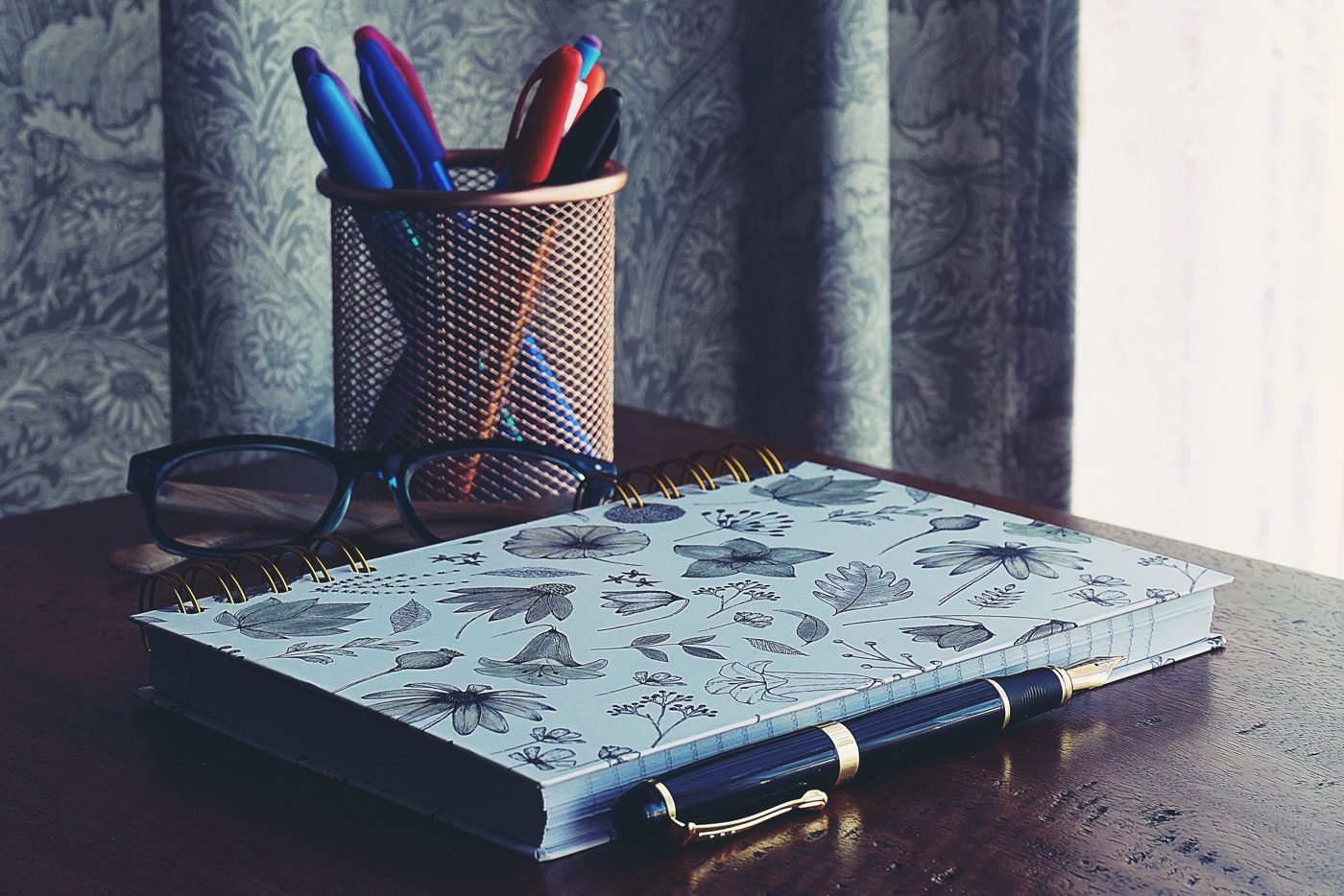 Open notebook and pen on a wooden writing desk