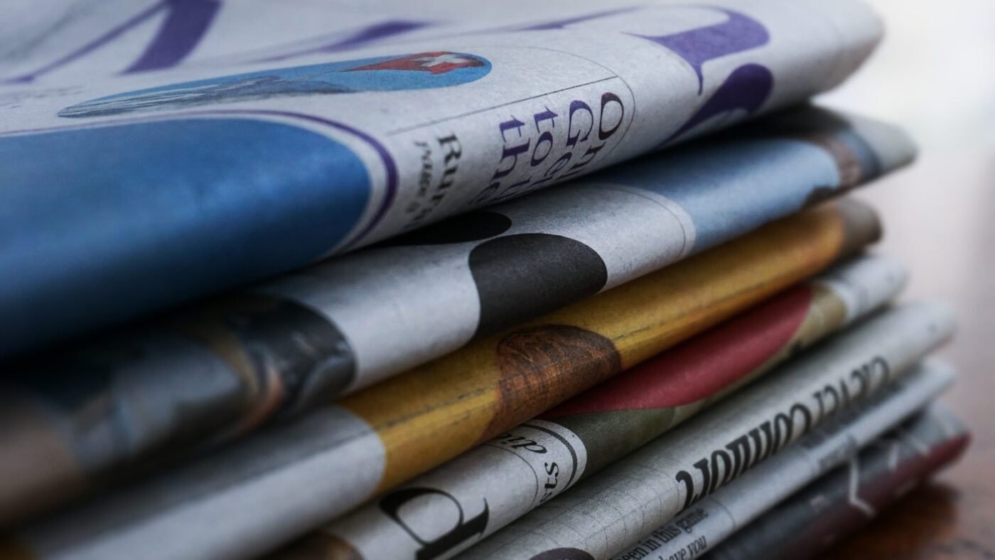 Stack of folded colorful newspapers on a wooden table