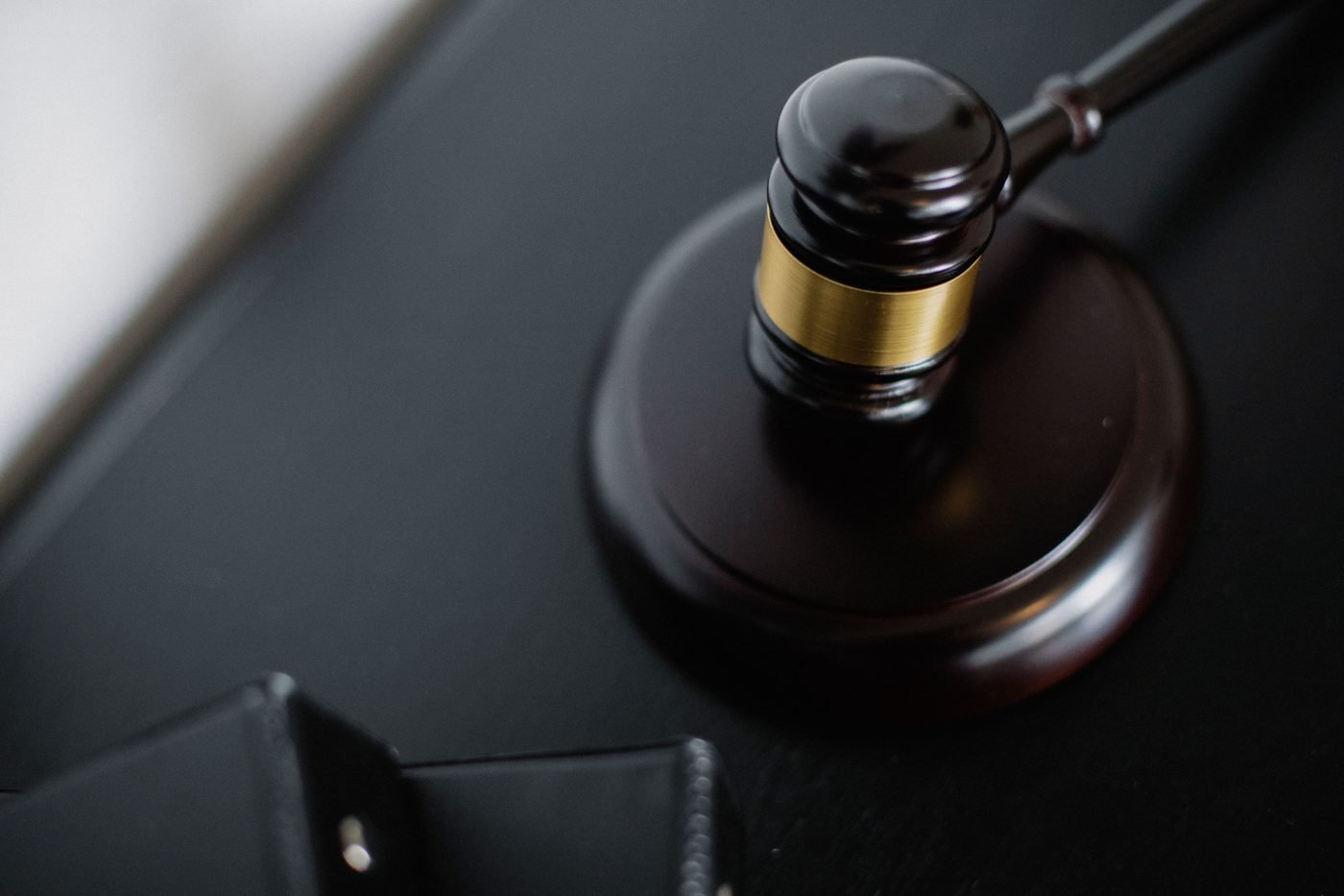 Wooden judge's gavel resting on a dark desk