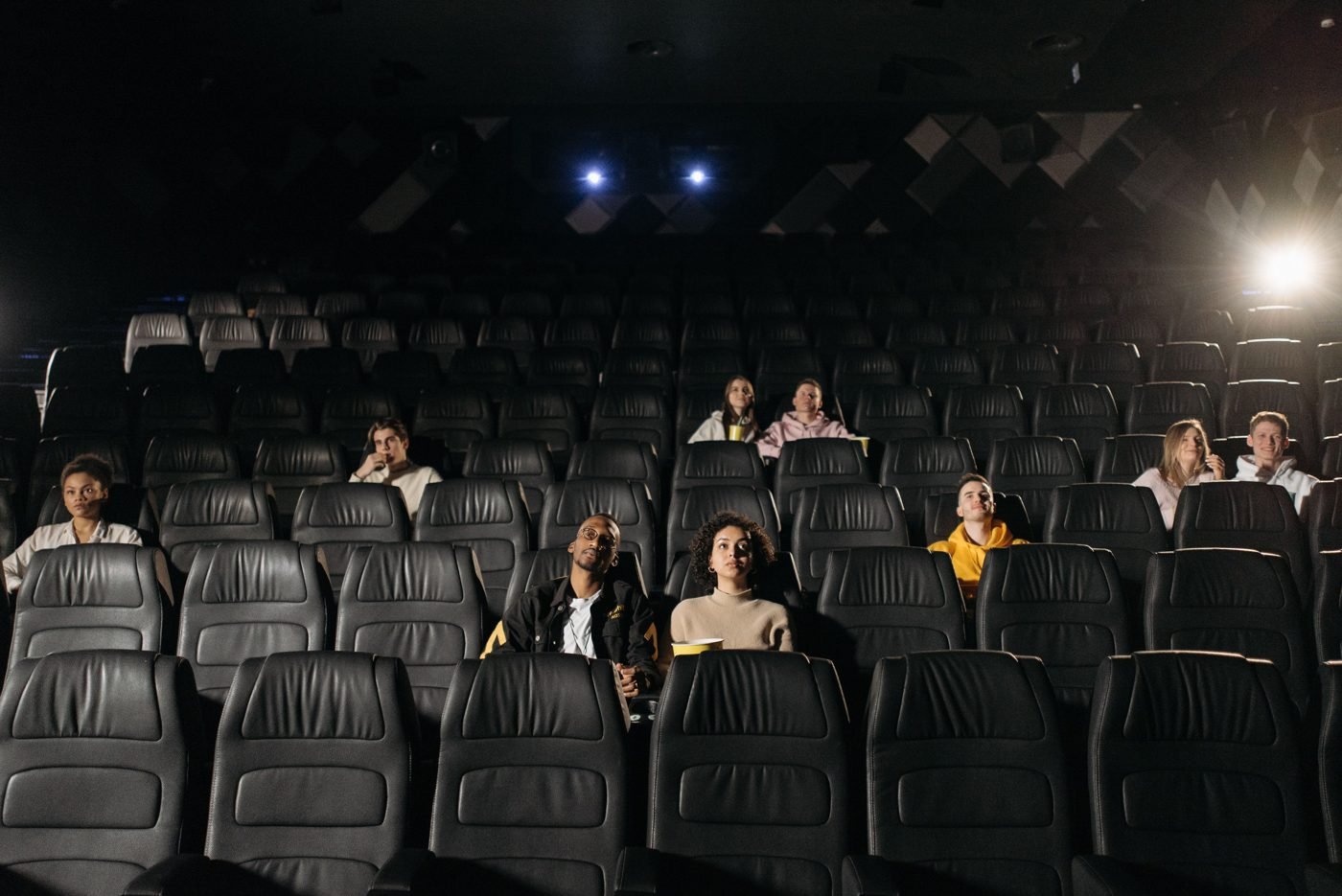 Audience seated in a dimly lit cinema hall