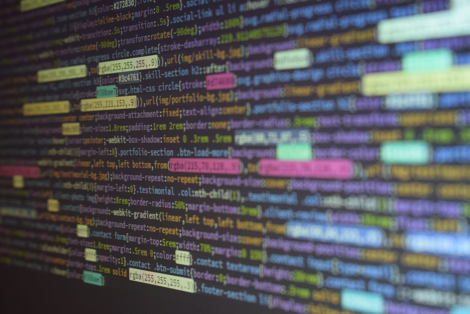 Close-up of colorful lines of code on a dark screen, illustrating AI-written game code