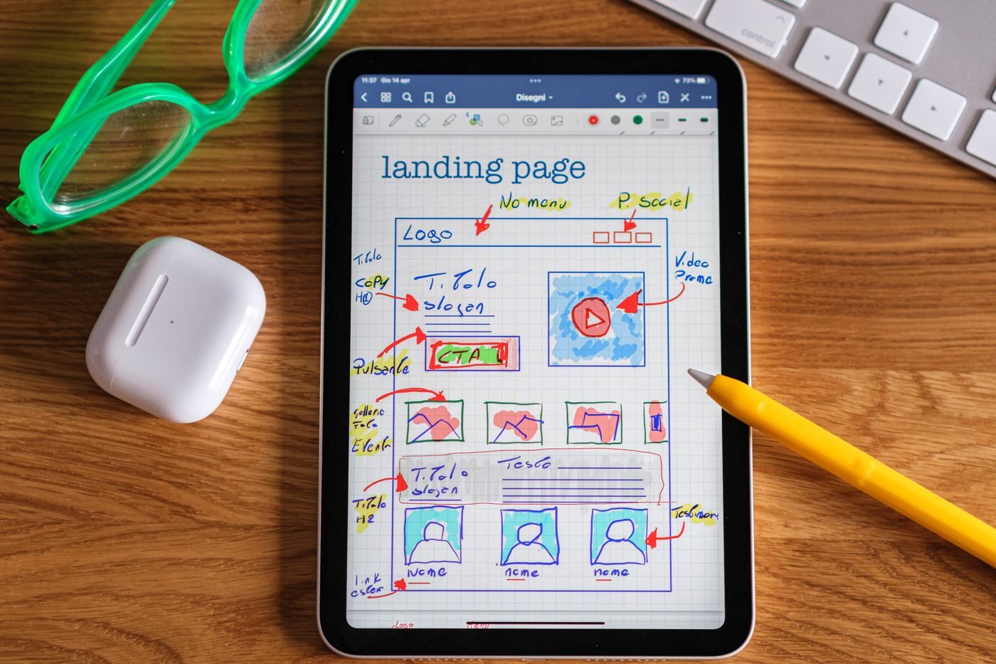 Tablet displaying a hand-drawn landing page wireframe beside a pencil