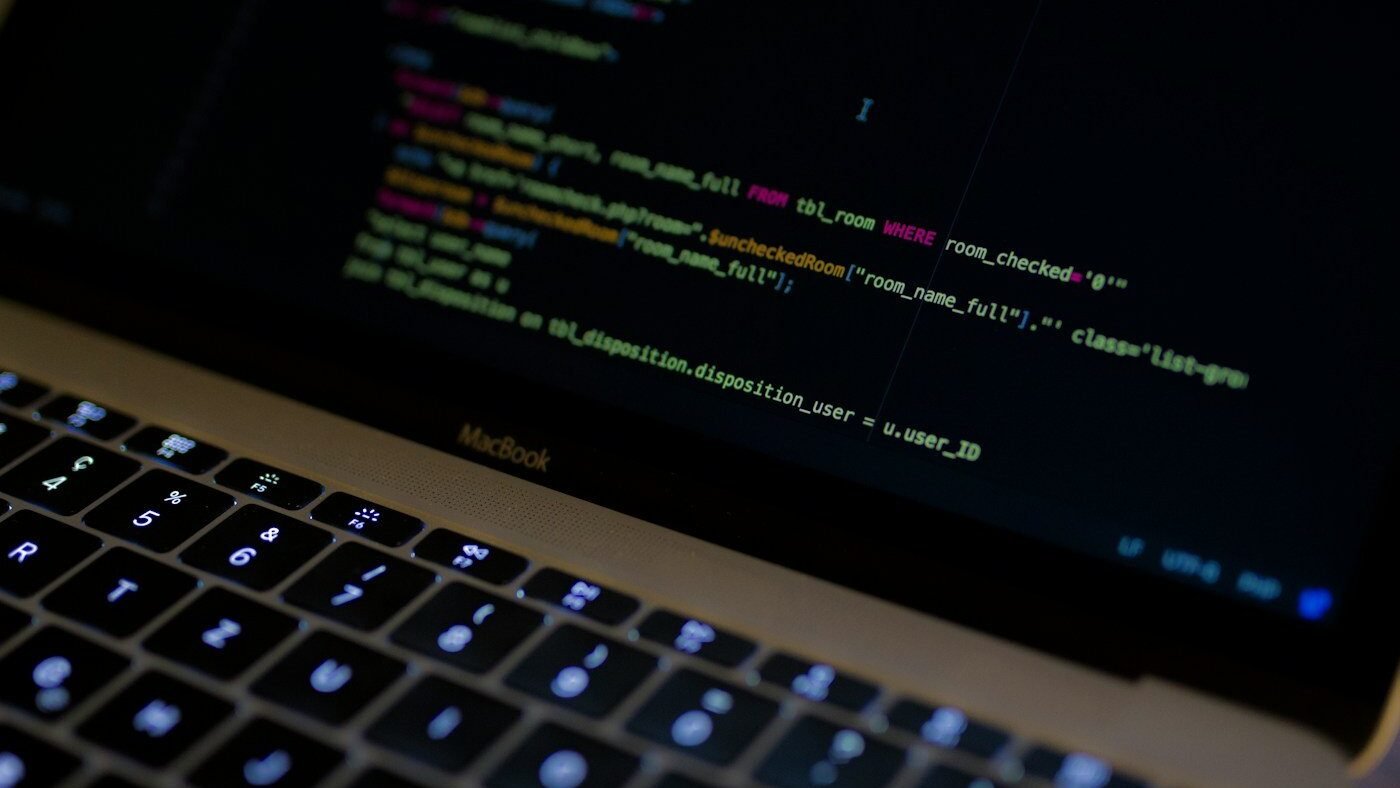 Code glowing on a dark screen, representing the thousands of programs AI agents wrote to beat Minecraft