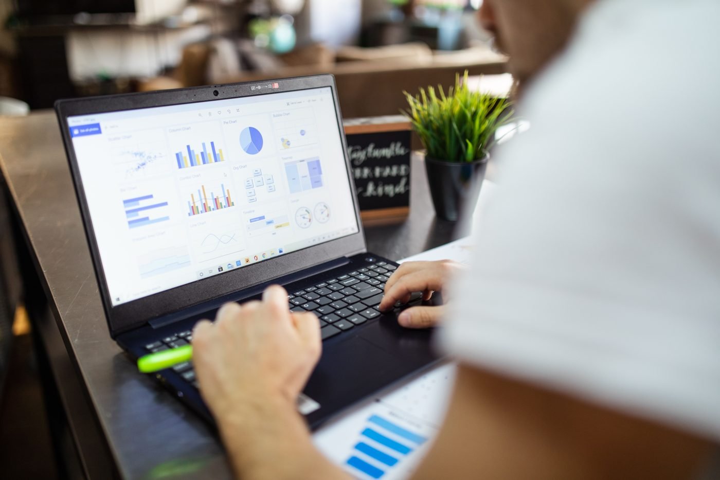 Person reviewing charts and data on a laptop at a desk