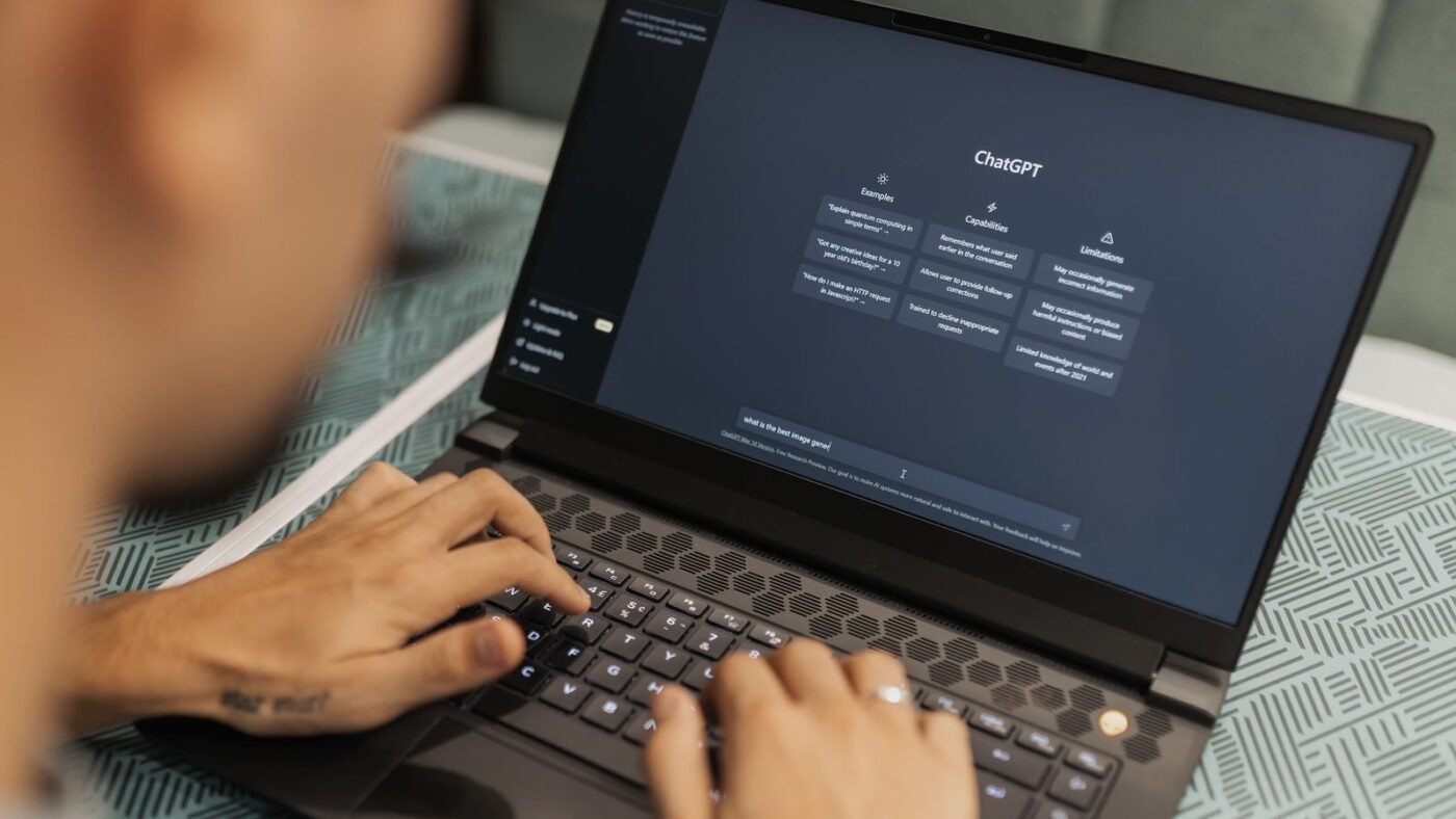 Person typing on a laptop showing the ChatGPT interface