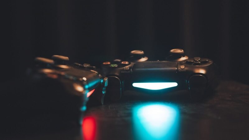 Glowing game controllers on a dark surface