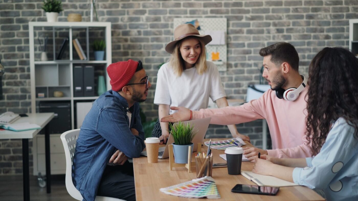 Team of young professionals brainstorming together around an office desk
