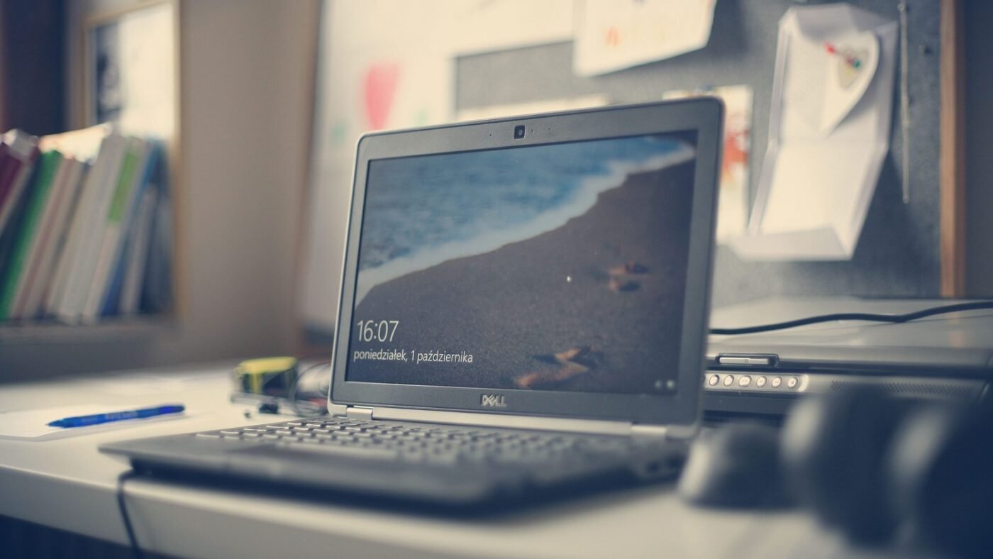 Laptop on a tidy desk with books and stationery in a modern workspace