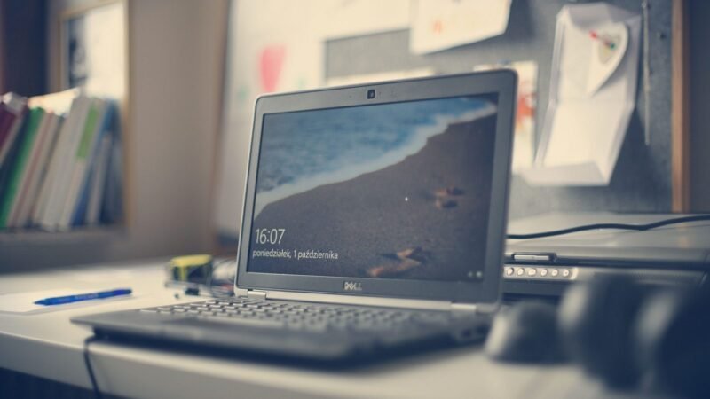 Laptop on a tidy desk with books and stationery in a modern workspace