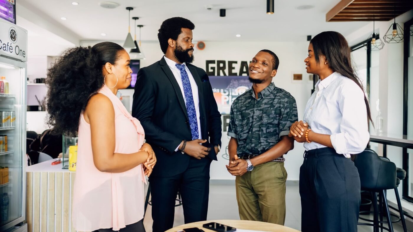 Four colleagues standing and talking in a quick office meeting