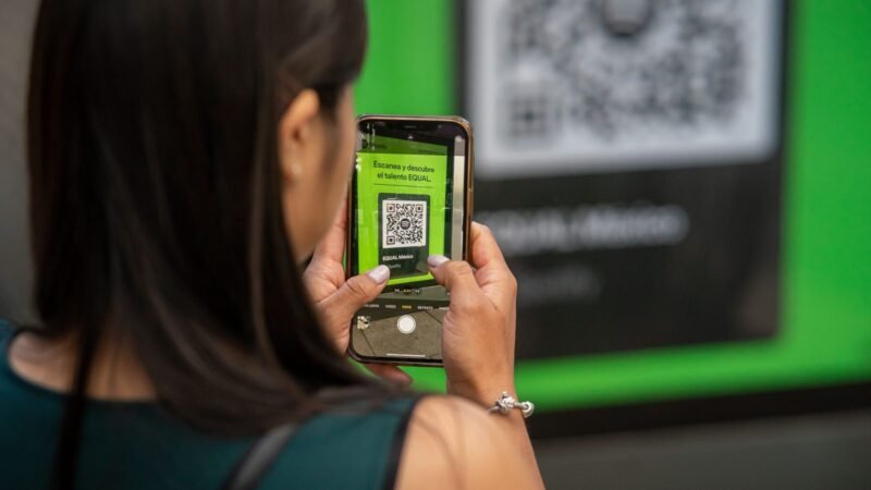 Woman scanning a QR code on a screen with her smartphone