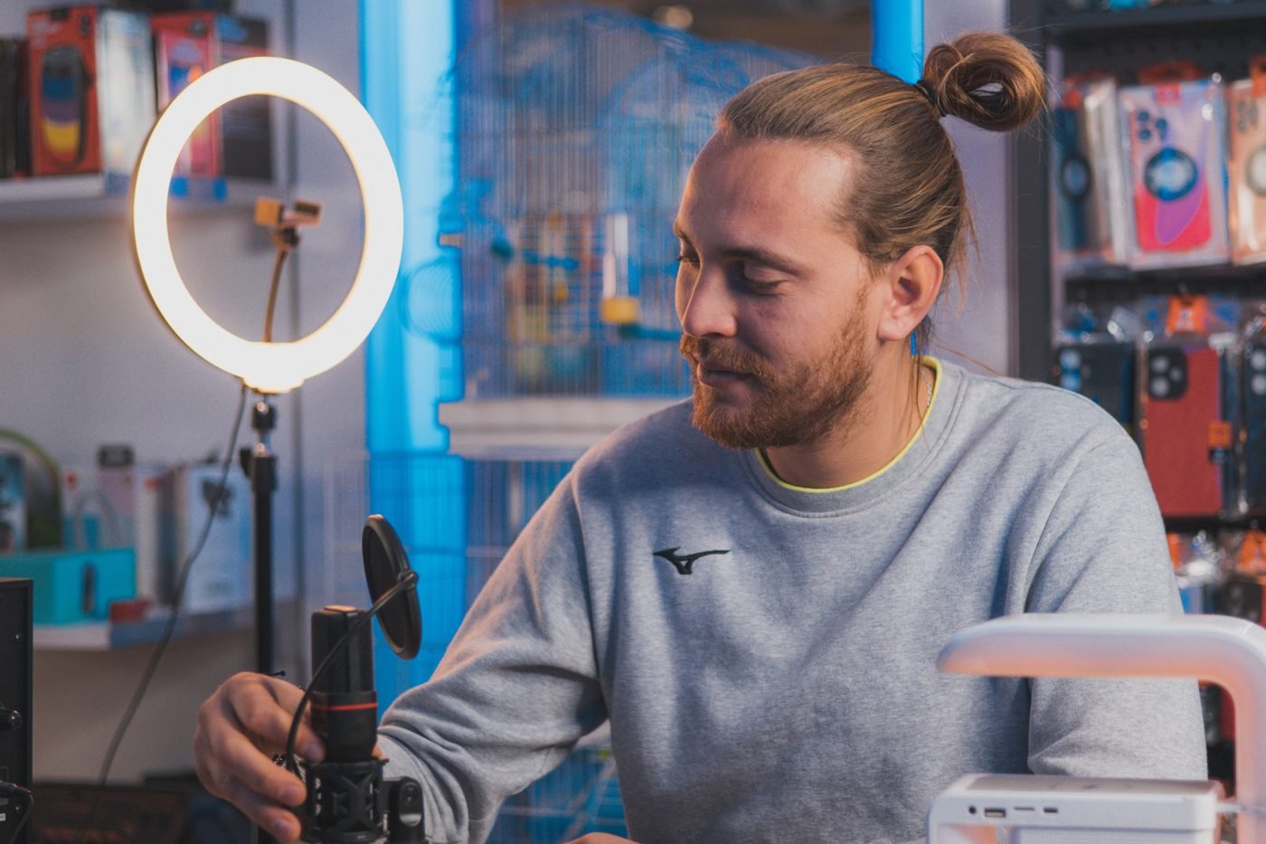 Man adjusting a ring light and camera in a home studio