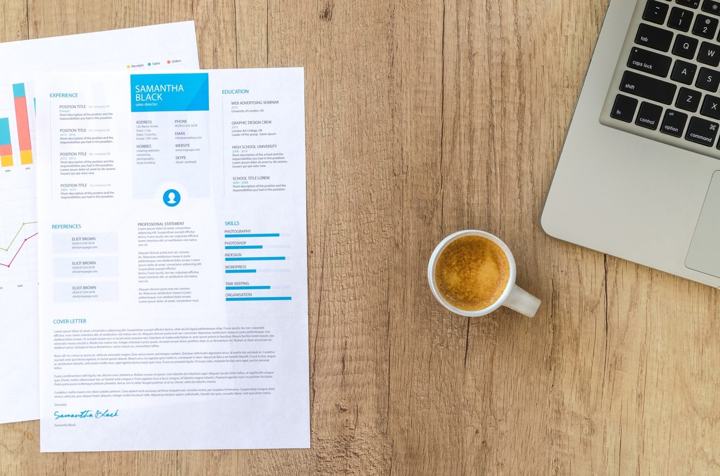 Top view of a printed resume, coffee cup and laptop on a wooden desk