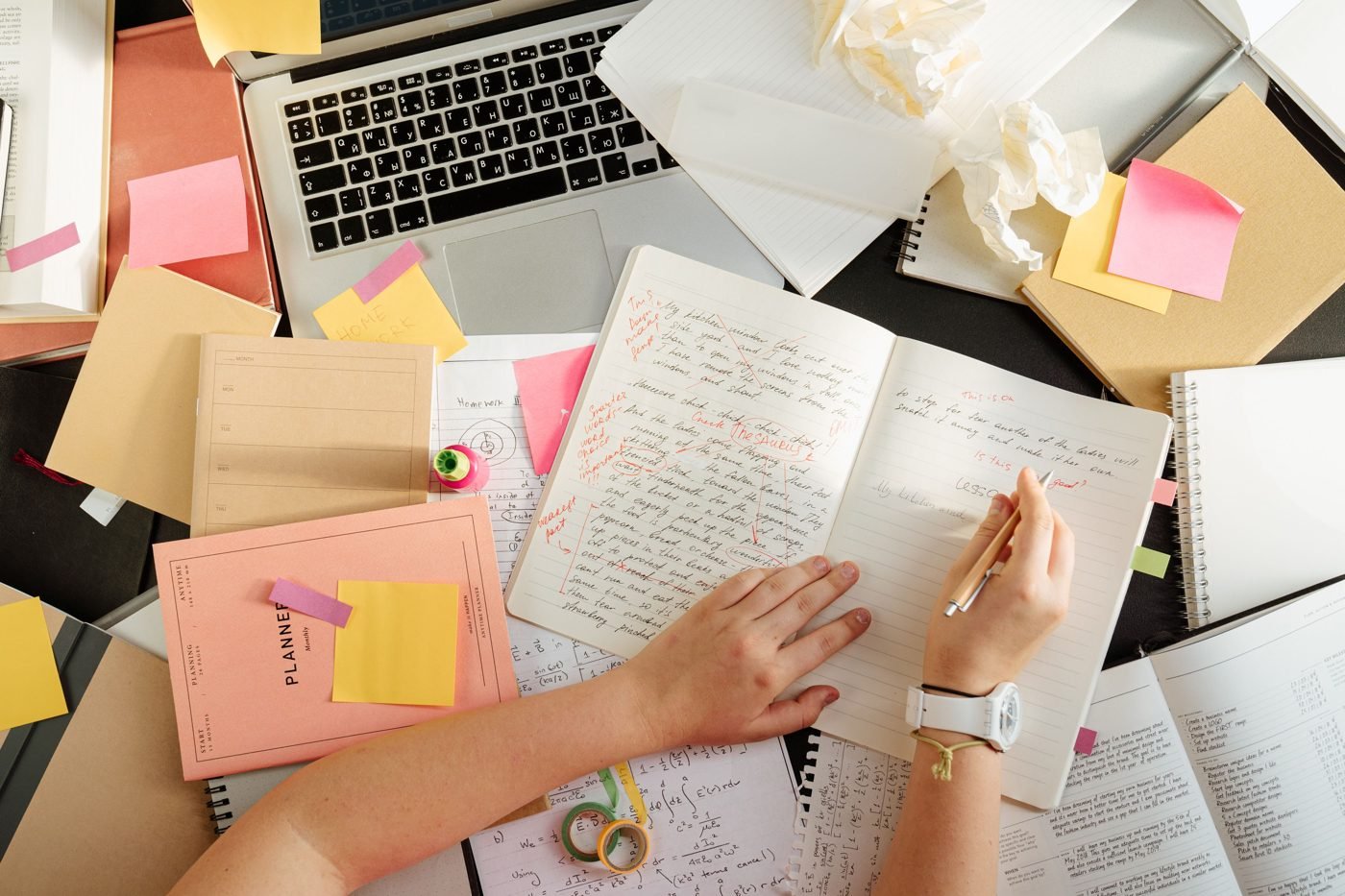 Overhead view of a desk covered in handwritten study notes and sticky notes