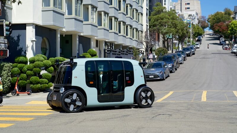 An autonomous vehicle with roof-mounted sensors crossing a city street, representing the inDrive and Pony.ai robotaxi partnership
