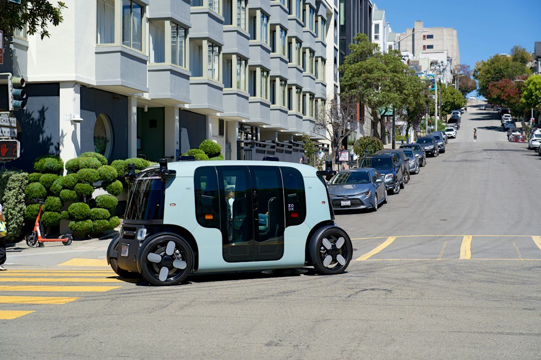 An autonomous vehicle with roof-mounted sensors crossing a city street, representing the inDrive and Pony.ai robotaxi partnership