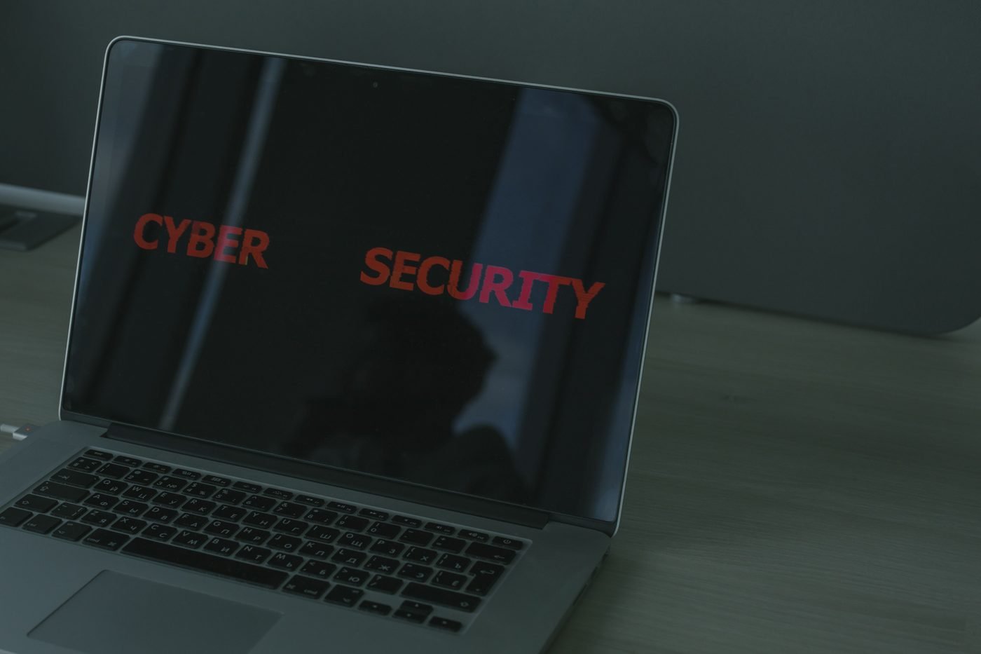 Laptop screen displaying the words cyber security in red