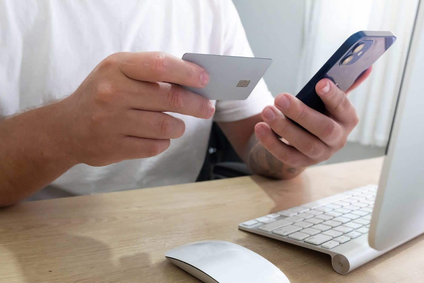 Person holding a credit card and smartphone to place an online order
