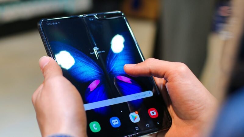 Person holding an unfolded foldable smartphone