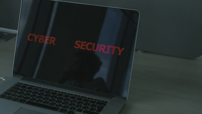 Laptop screen showing cybersecurity text in a dark workspace