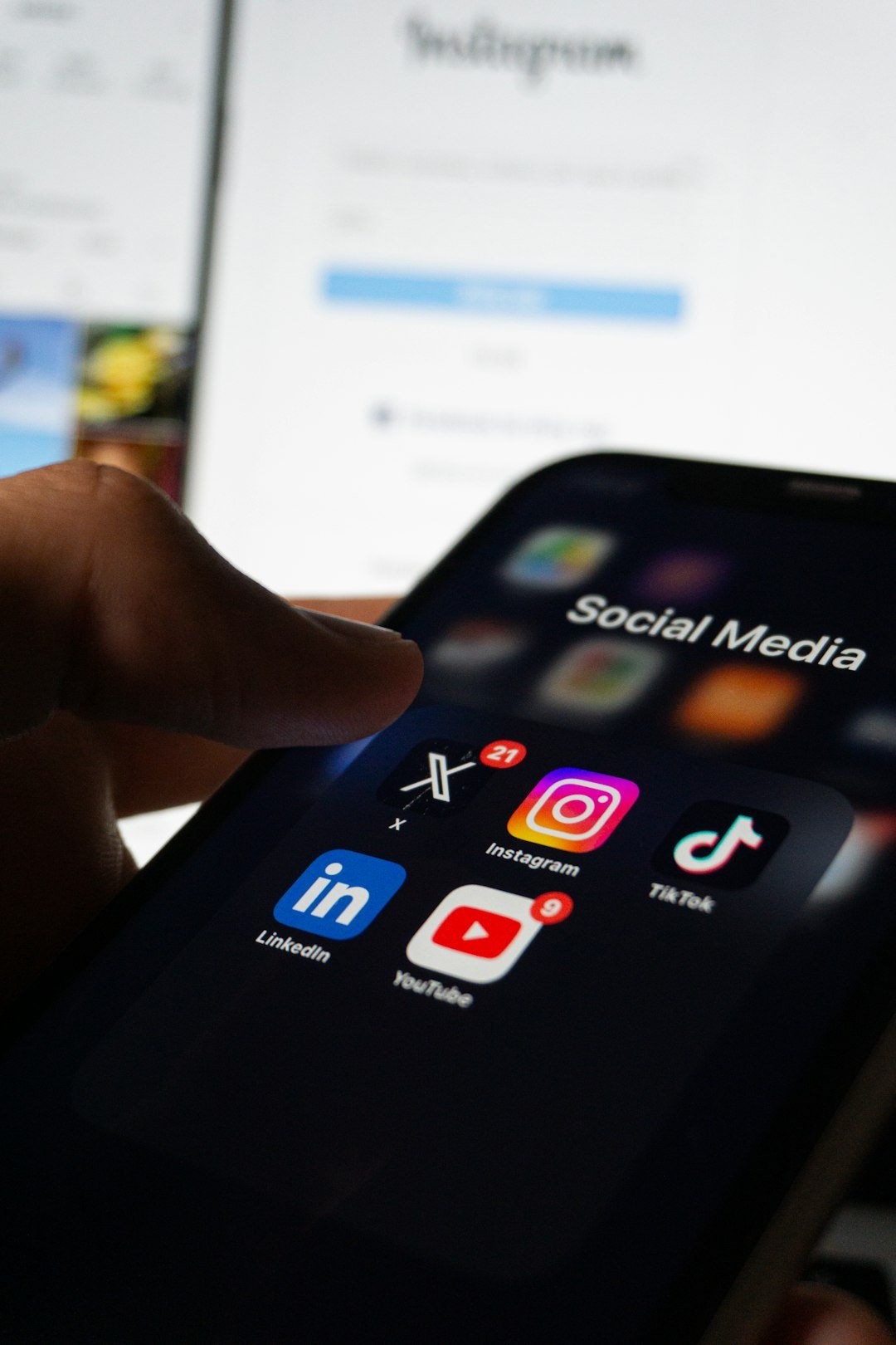 Phone screen showing social media app icons in dark lighting