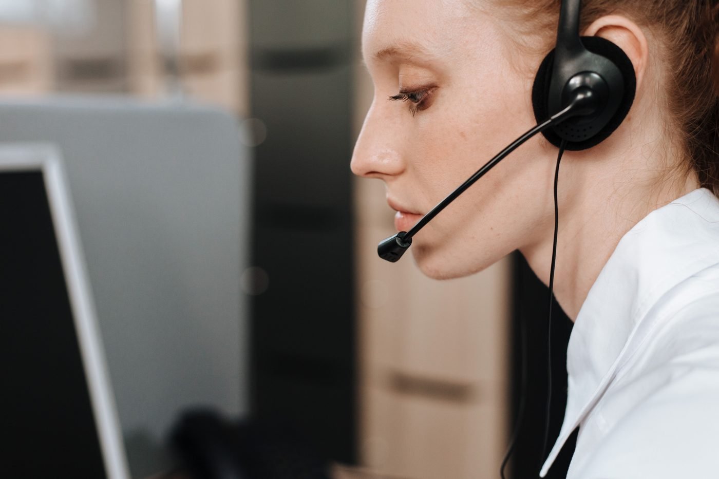Call center agent wearing a headset while working at her desk