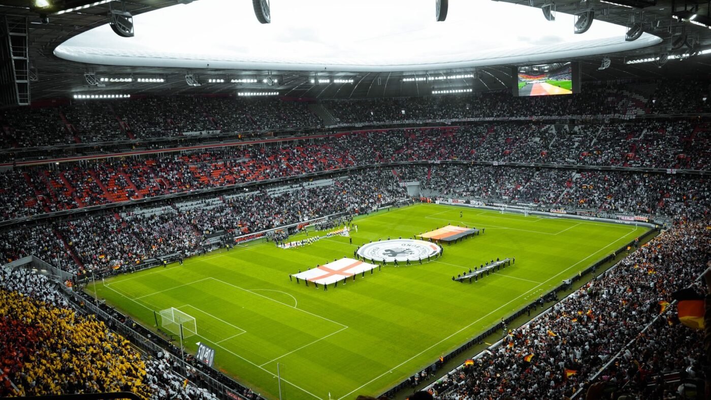Packed football stadium under lights with fans filling the stands before a match