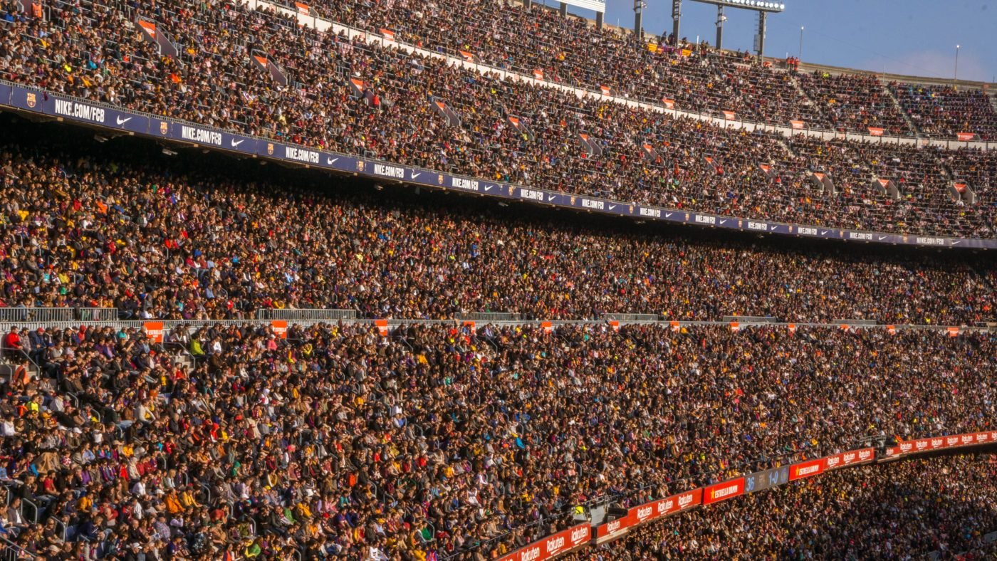 Huge crowd filling the tiers of a football stadium during a match