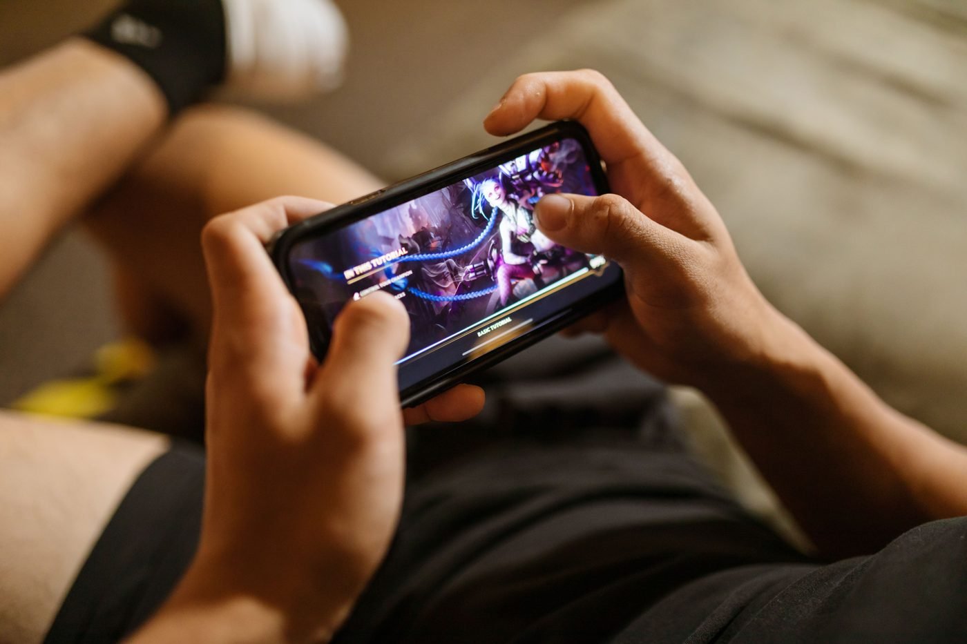 Person holding a smartphone sideways while playing a mobile video game