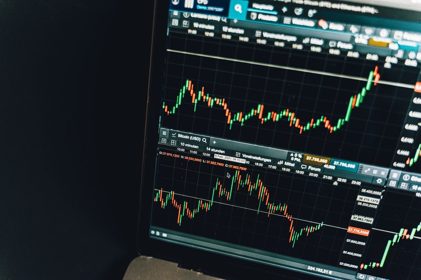 Laptop screen showing stock market candlestick charts