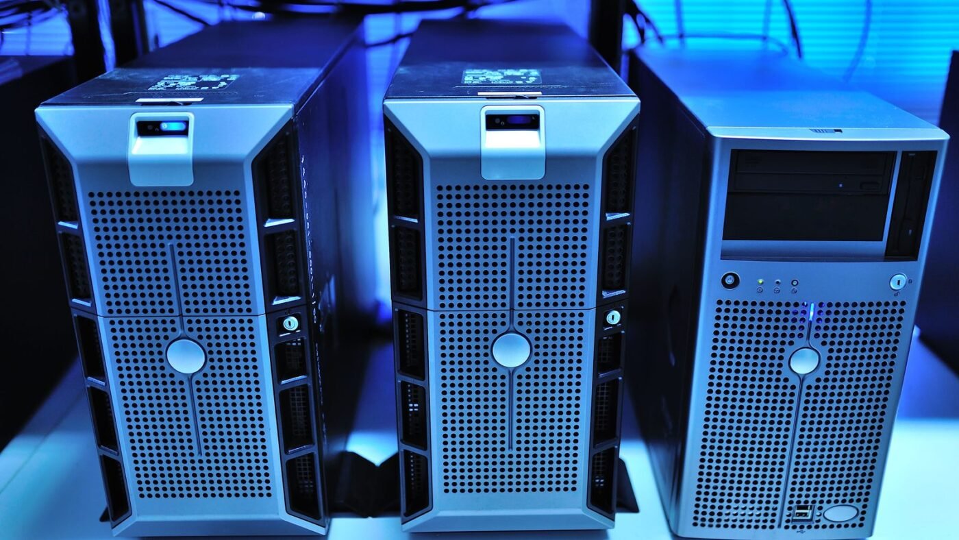Three tower computer units lit in blue on a desk