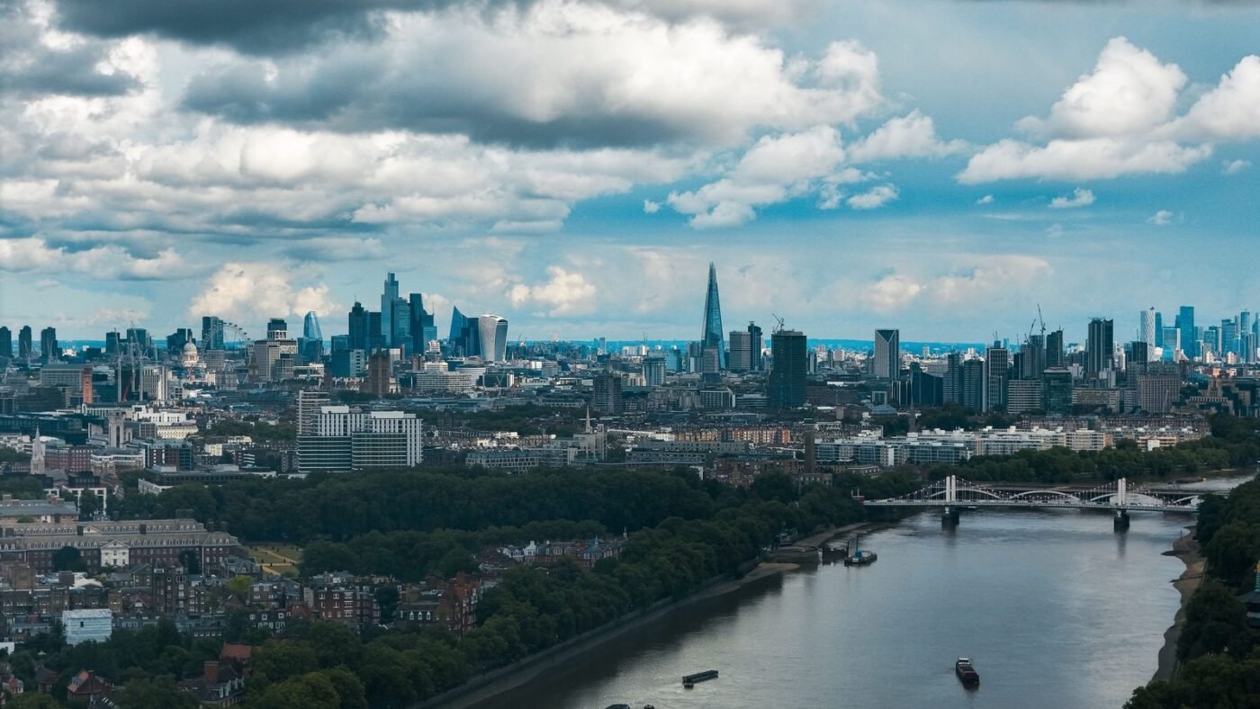 Wide view of the London skyline and the River Thames under a dramatic sky
