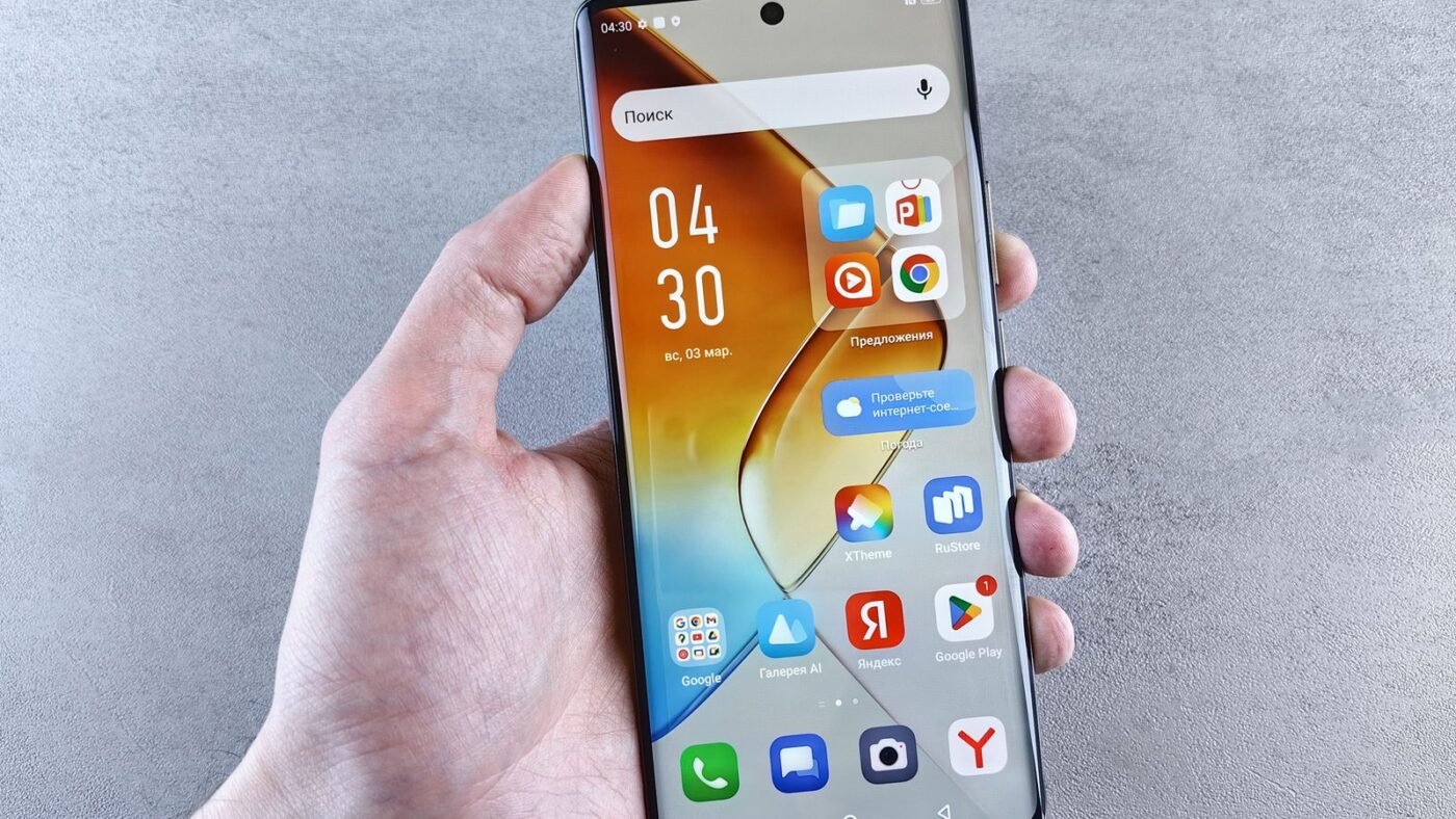 Hand holding a smartphone showing apps on its screen