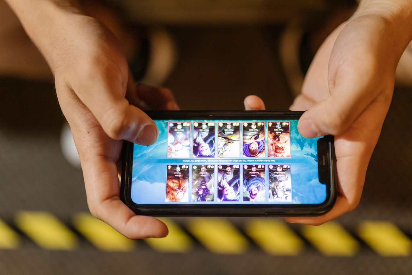 Close-up of hands playing a mobile game on a smartphone