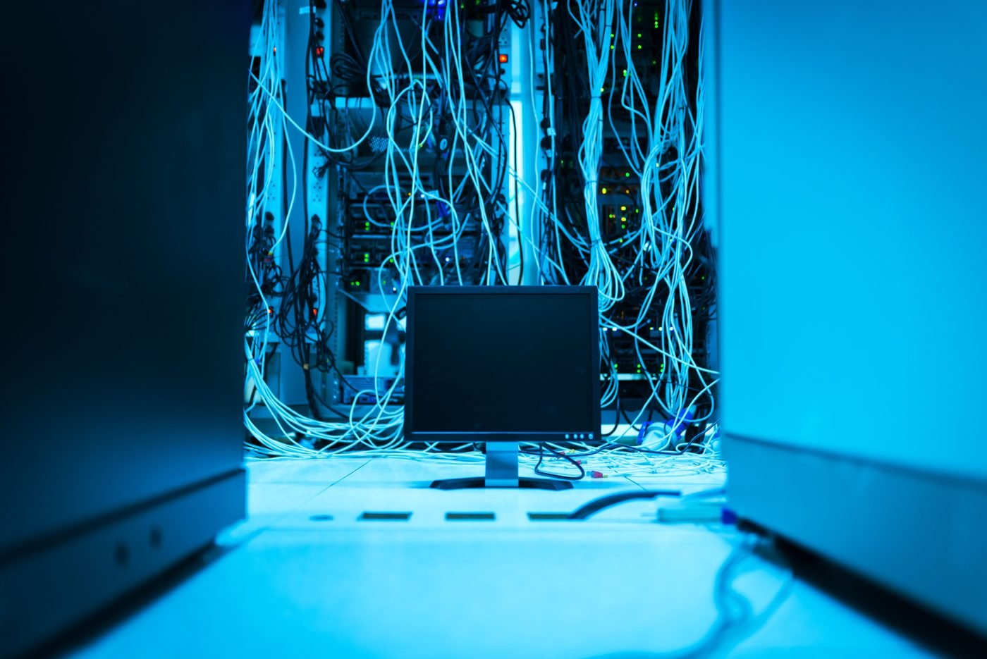 Glowing server rack wiring in a dark data center room