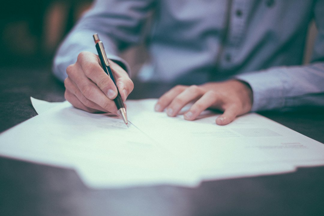 Someone signing a legal document with a pen